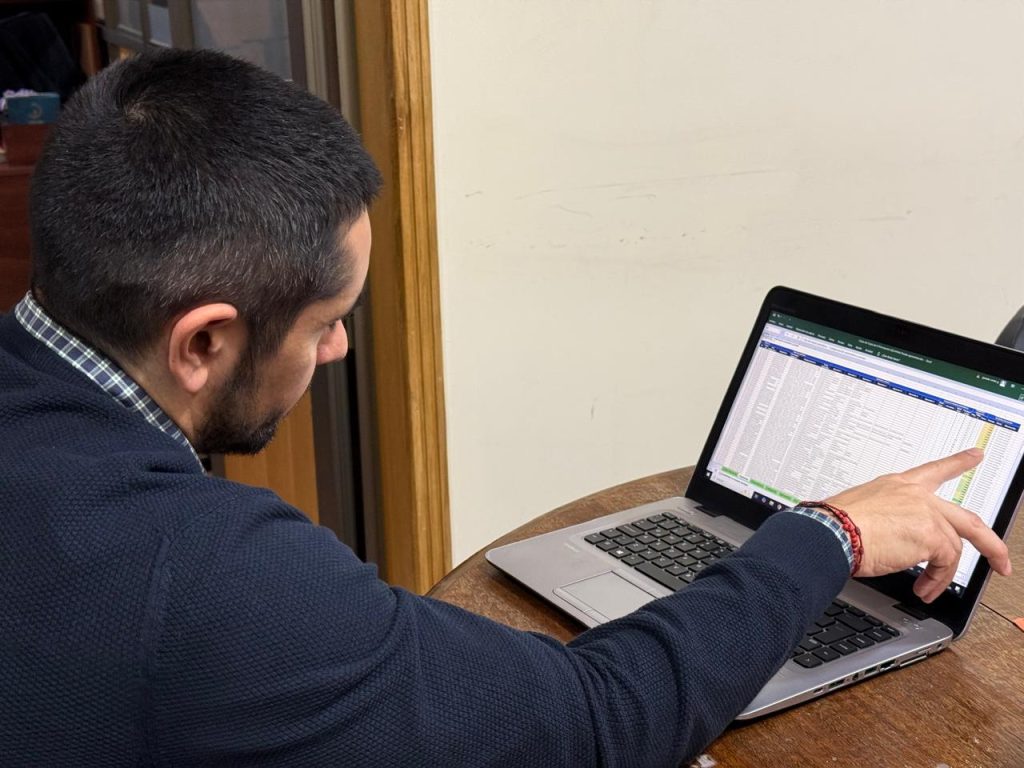 Profesional revisa en un computador la planilla de la lista de espera quirúrgica en Temuco